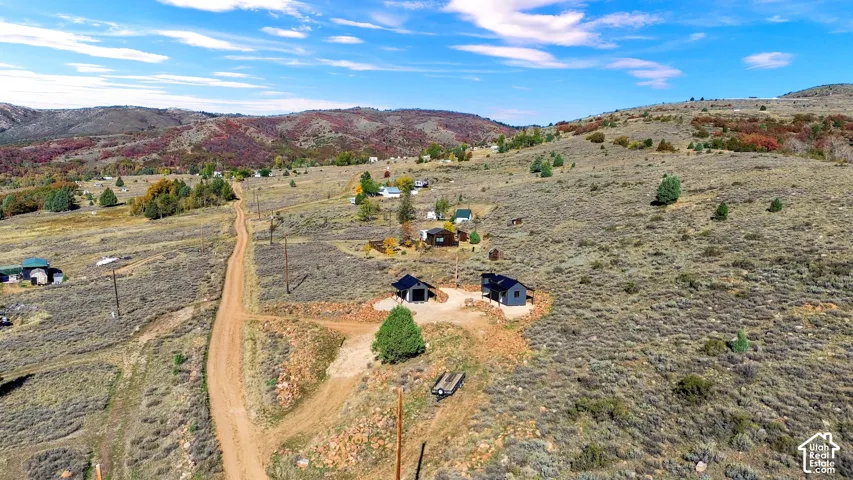 Expansive land parcel with surrounding hillsides, natural vegetation, and distant structures