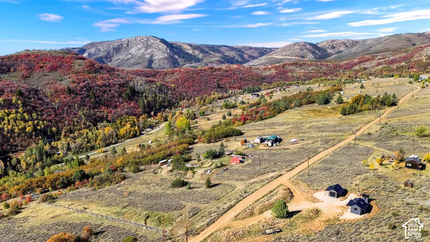 Expansive terrain featuring varied topography, mature trees, and mountainous backdrops