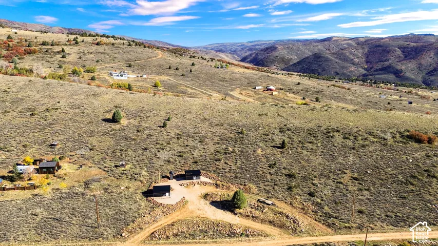 Expansive mountainous terrain with multiple structures and a dirt road network