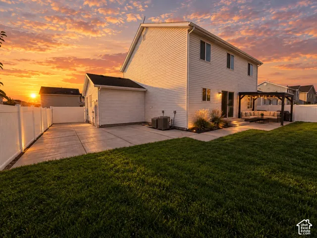 Exterior featuring horizontal siding, a concrete patio, a covered pergola, a vinyl privacy fence, and a manicured lawn
