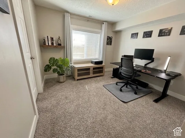 Room with wall-to-wall carpeting, neutral paint, a single-panel interior door, window with blinds, and a built-in floating wooden shelf