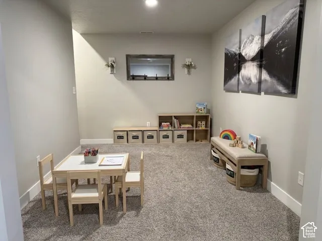 Neutral-toned interior space featuring wall-to-wall carpeting and recessed ceiling lighting