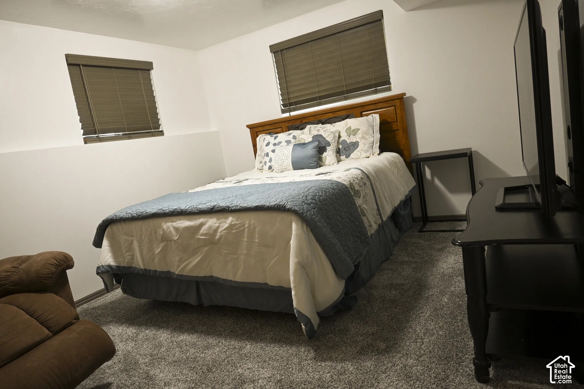 Wall-to-wall carpeting, neutral wall finish, and dual windows with fitted privacy shades