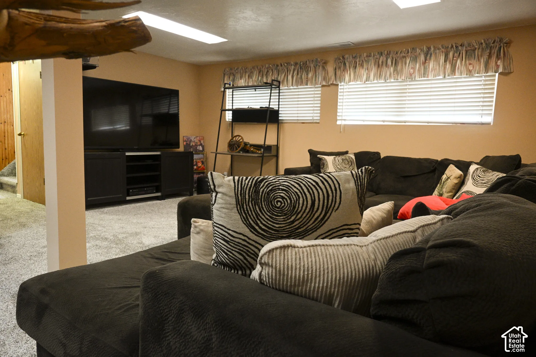 Neutral-toned interior space featuring recessed ceiling lighting, wall-to-wall carpeting, and horizontal window blinds