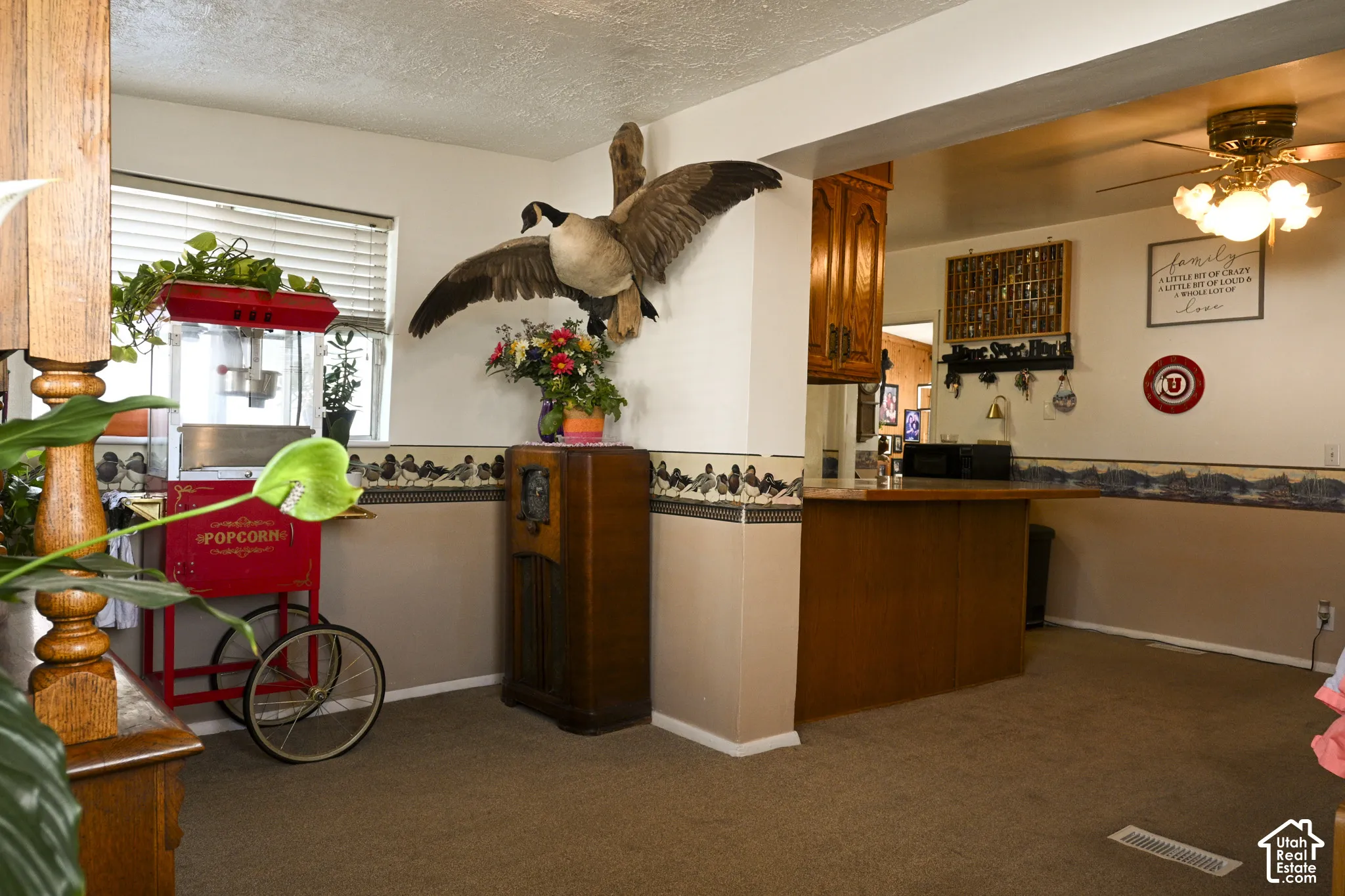 Interior space featuring a wooden breakfast bar, ceiling-mounted multi-light fixture, and horizontal window blinds