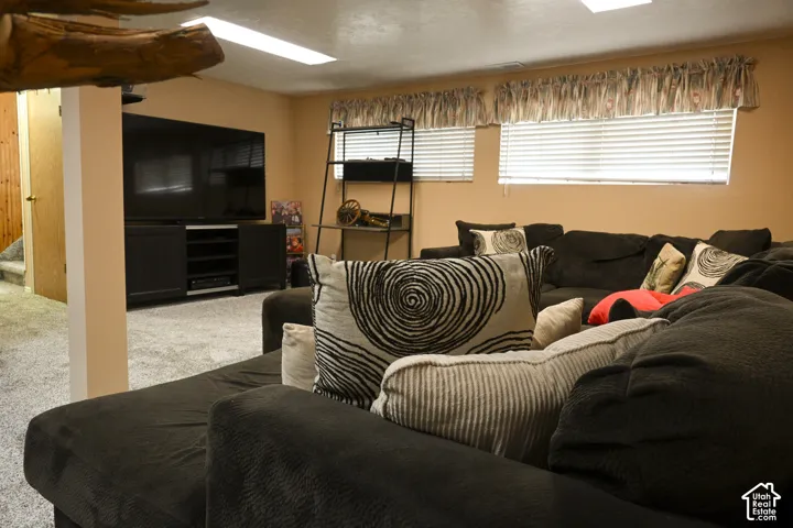 Neutral-toned interior space featuring recessed ceiling lighting, wall-to-wall carpeting, and horizontal window blinds