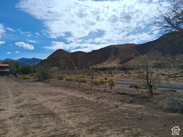 Expansive lot featuring native desert landscaping, wire fencing, and prominent mountain backdrops