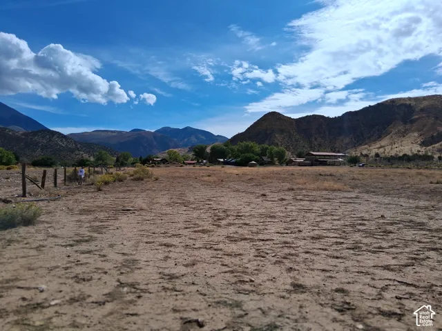 Expansive acreage featuring wire fencing and mountainous horizon backdrop
