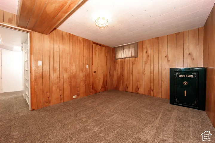 Wood-paneled interior walls, textured ceiling tiles, flush-mount ceiling lighting, and wall-to-wall carpeting