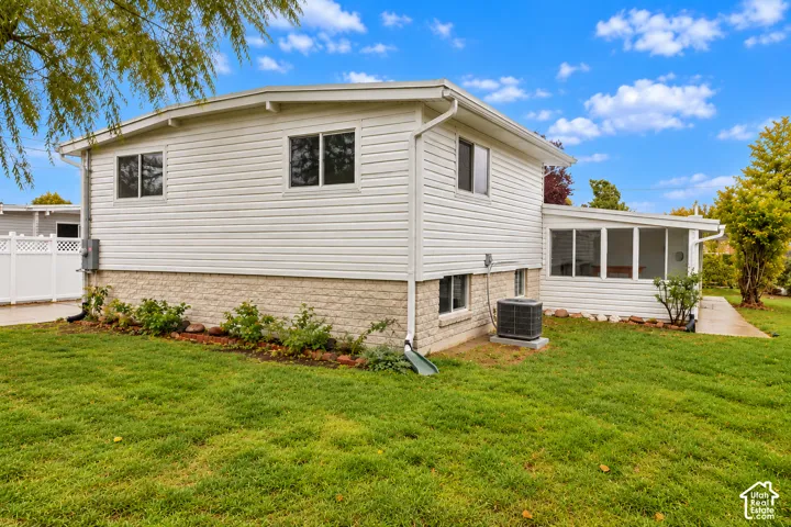 Exterior featuring horizontal siding, stone veneer base, enclosed patio, and vinyl privacy fencing