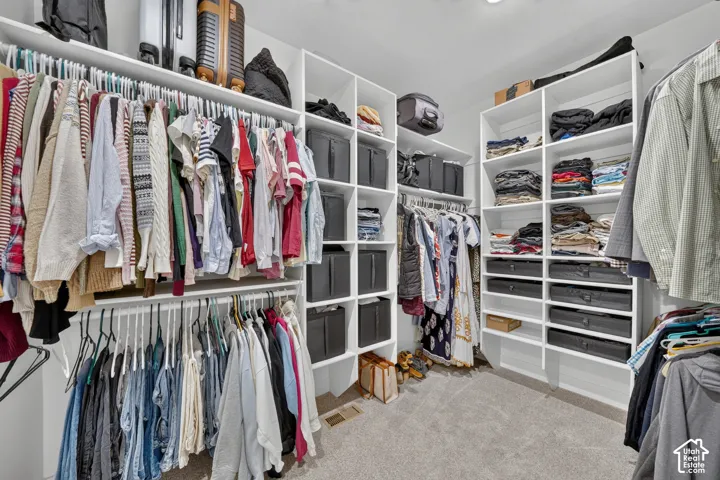 Custom walk-in closet featuring white built-in shelving, multiple hanging rods, and integrated storage compartments