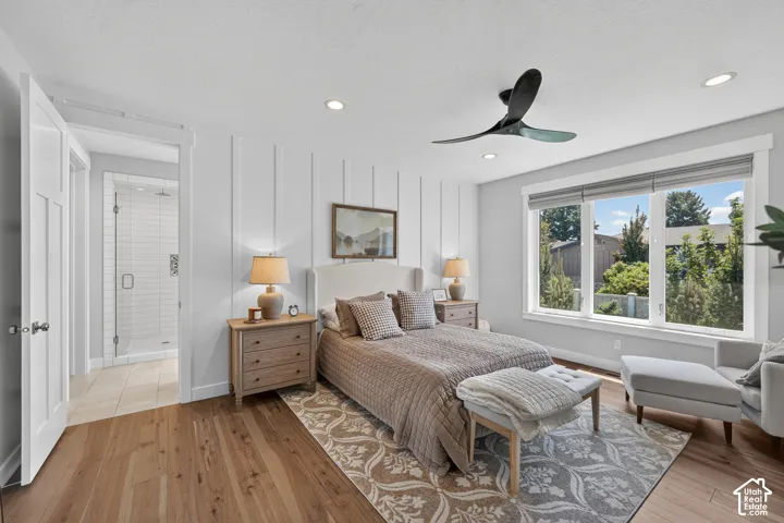 Bedroom featuring board and batten accent wall, wood-finish flooring, recessed lighting, modern three-blade ceiling fan, and large windows