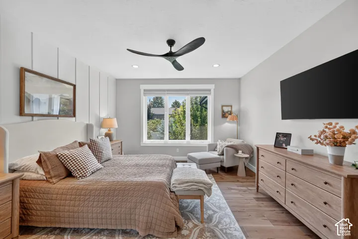 Board-and-batten accent wall, wood-finish flooring, multi-pane window, matte black three-blade ceiling fan, and recessed lighting