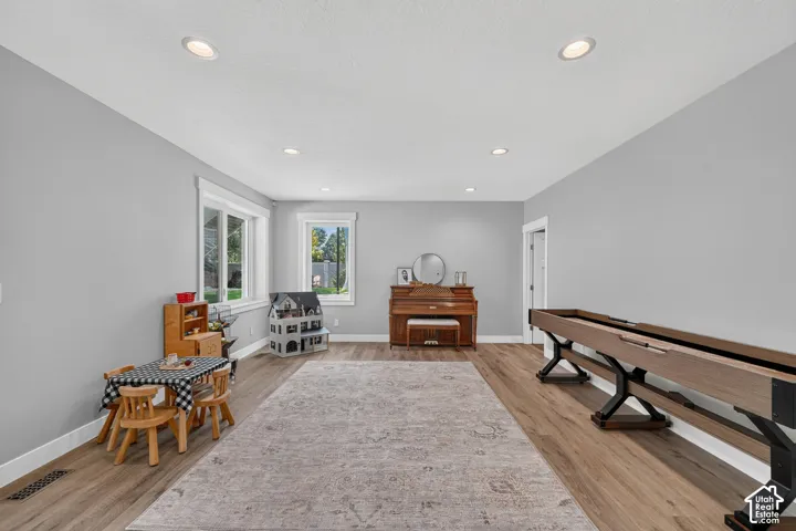 Spacious interior featuring wood-finish flooring, neutral wall paint, recessed lighting, and dual windows with casing