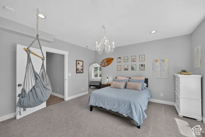 Neutral-toned interior space featuring recessed lighting, a multi-arm decorative chandelier, and carpeted flooring