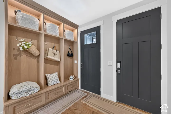 Built-in mudroom cabinetry with integrated recessed lighting, wood-finish shelving, and storage drawers
