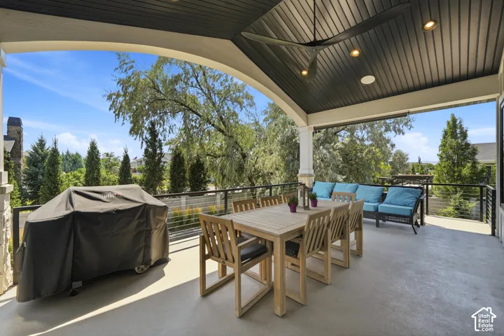 Covered patio featuring a high-contrast dark beadboard ceiling, recessed lighting, a ceiling fan, and black cable railing