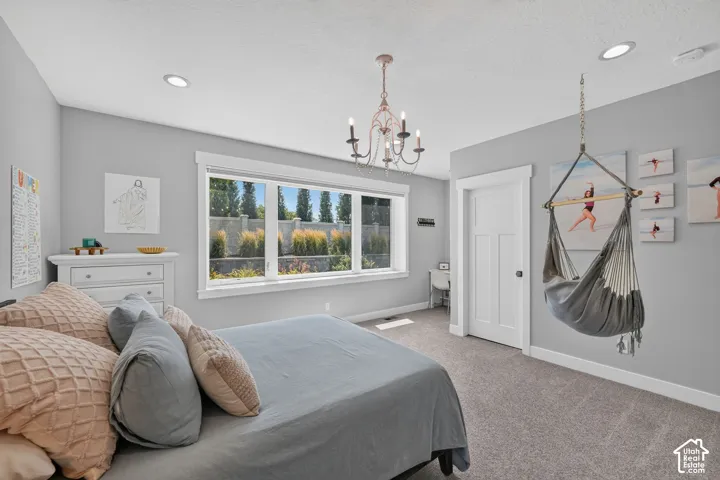 Room featuring a large picture window, recessed lighting, a decorative chandelier, and a solid-core single-panel door with architectural trim