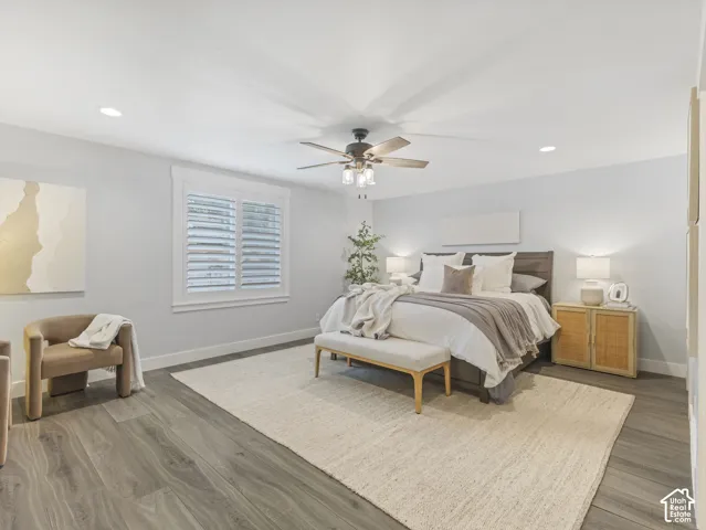 Room featuring wood-finish flooring, recessed lighting, a ceiling fan with integrated light fixture, and plantation shutters