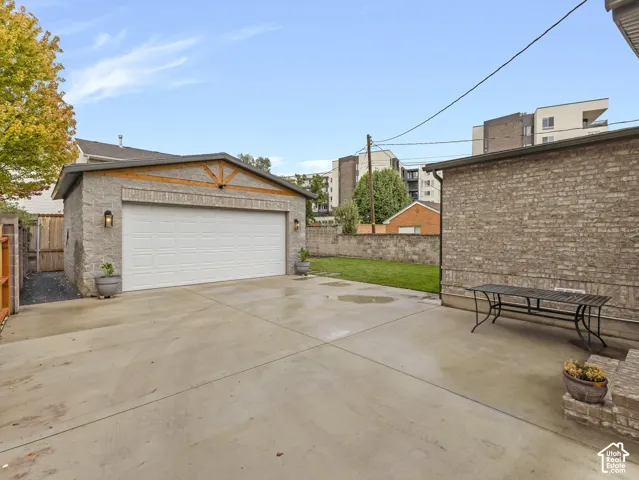 Detached two-car garage with masonry exterior, concrete driveway, and enclosed backyard featuring perimeter wall fencing