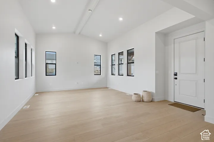 Vaulted ceilings featuring recessed lighting, light LVP flooring, and expansive windows with black frames
