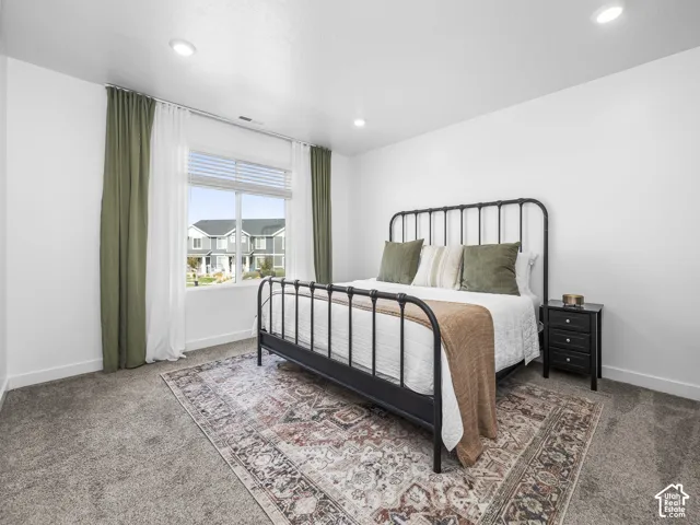 Room featuring neutral carpeting, recessed ceiling lighting, and a window with horizontal blinds