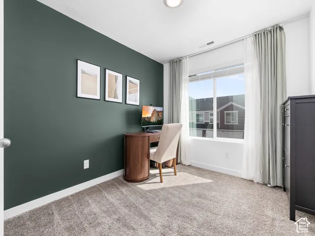 Room featuring a dark-toned accent wall, wall-to-wall carpeting, and a large window with white frame trim