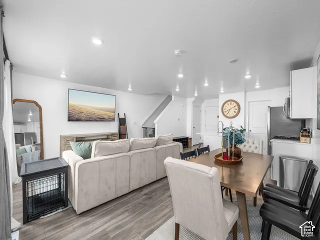 Open-concept interior featuring wood-finish flooring, recessed lighting, and a neutral color palette