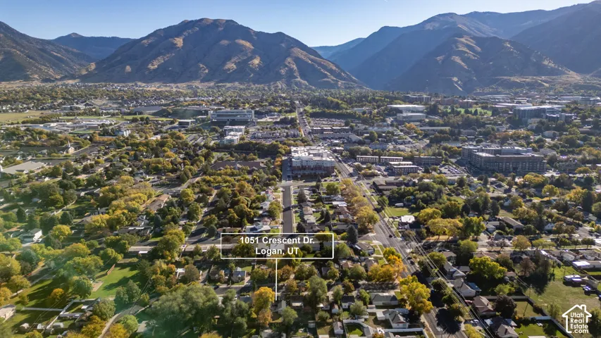 Aerial perspective of Logan, Utah, featuring mountainous topography and mature neighborhood canopy