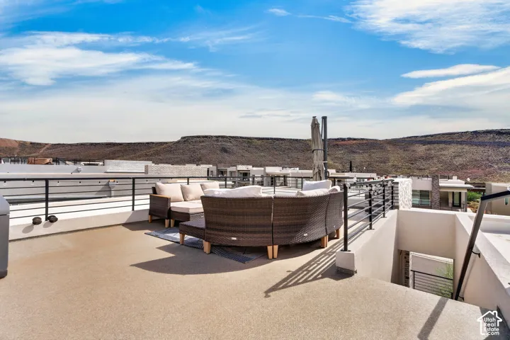 Rooftop deck featuring a textured surface, metal railing, and a desert mountain backdrop