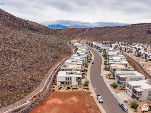 Aerial perspective featuring modern multi-level residences, flat roof architecture, paved thoroughfares, and desert landscape surroundings