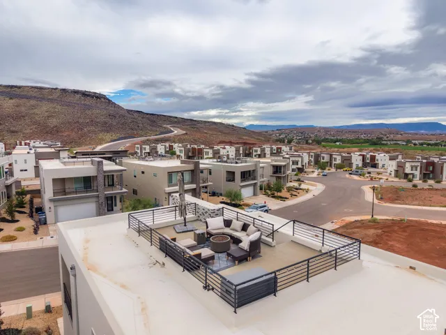 Rooftop terrace featuring concrete surfacing and black metal railing, set against a mountain backdrop