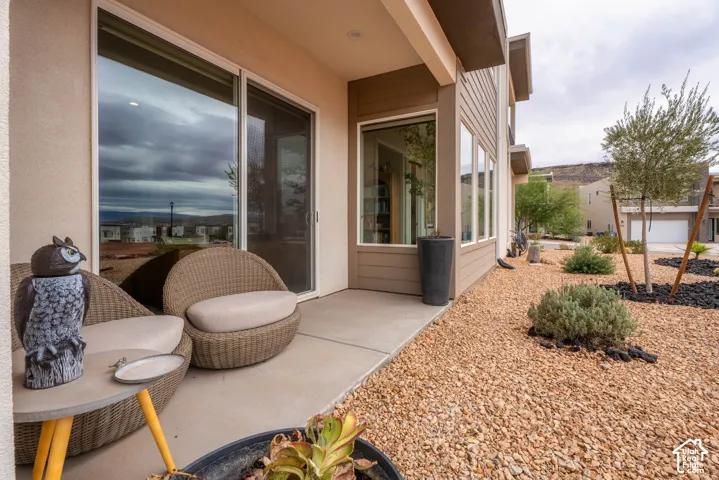 Concrete patio featuring large sliding glass doors, multi-pane picture windows, and exterior horizontal siding