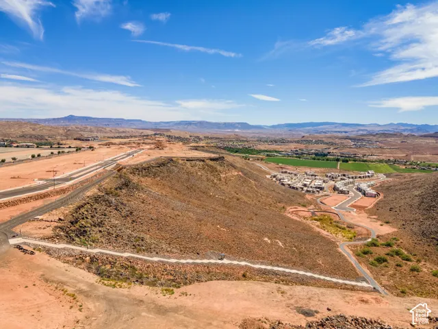 Aerial perspective of arid desert topography featuring natural rock formations, paved roadways, and mountainous surroundings