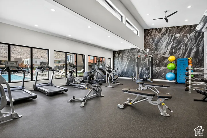 Fitness space featuring high ceilings, clerestory windows, recessed lighting, and resilient rubber flooring