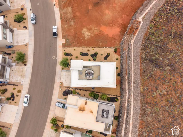 Aerial perspective of a multi-level residence featuring a flat roofline, integrated rooftop terrace, and desert landscaping