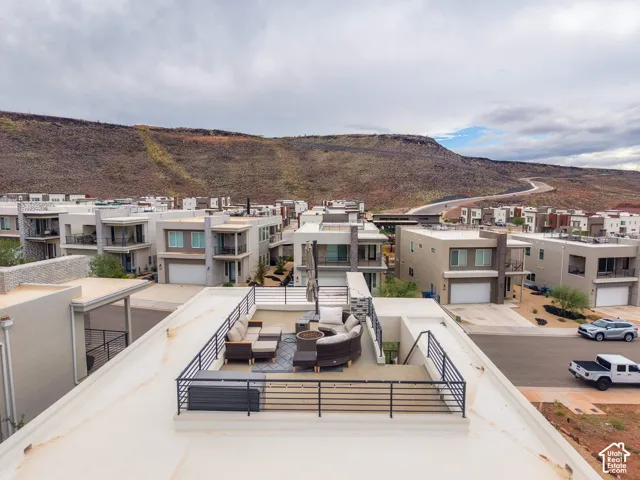 Rooftop deck featuring metal railings, built-in structural bench, and mountain backdrop