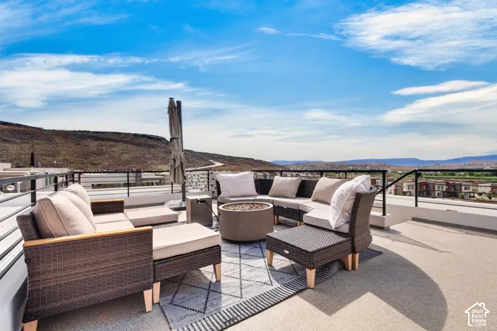 Rooftop terrace featuring concrete flooring, a low-profile metal railing system, and expansive mountain scenery