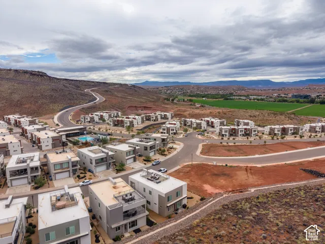 Multi-level modern residences featuring rooftop terraces, flat roofs, integrated garages, and desert landscape surroundings