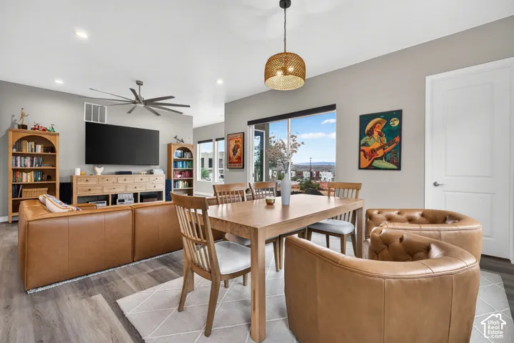 Open-concept space featuring wood-finish flooring, recessed lighting, a ceiling fan, and a prominent window with mountain backdrop