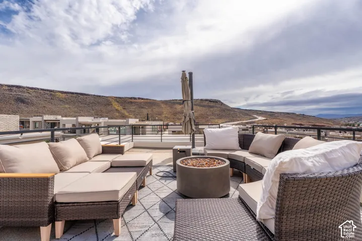Rooftop terrace featuring concrete hardscaping, metal railing, and mountain backdrop