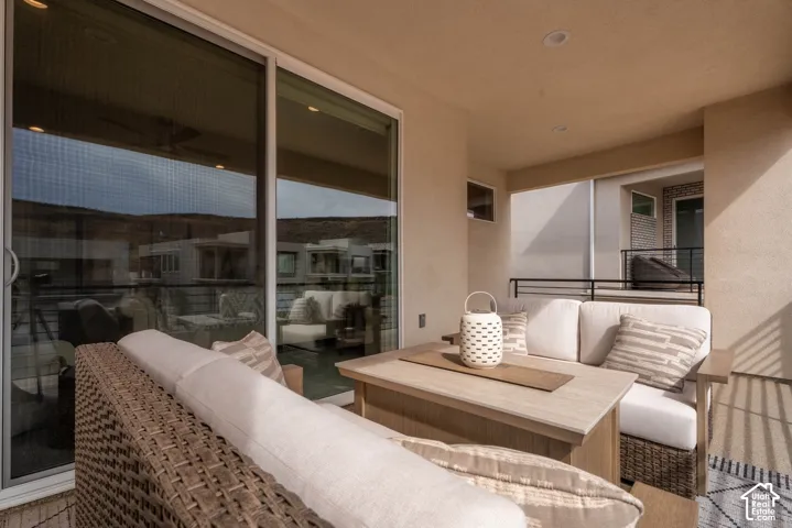 Covered patio featuring recessed lighting, a sliding glass door, and metal railing