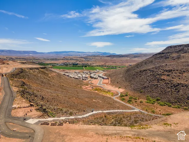 Aerial perspective of the landscape featuring paved thoroughfares, desert topography, regional mountain terrain, and localized walking paths