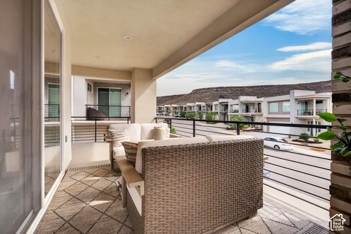 Covered balcony featuring recessed lighting, horizontal metal railings, and natural stone veneer accents
