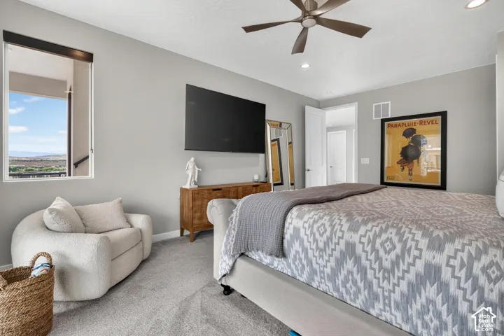 Neutral-toned bedroom featuring carpeting, a multi-speed ceiling fan, recessed lighting, and a window with natural light