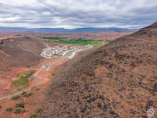 Aerial perspective featuring rugged desert terrain, paved roadways, and mountain backdrops