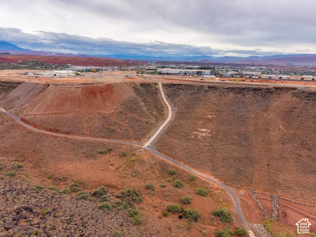 Expansive desert acreage featuring elevated topography, natural rock formations, and paved access paths