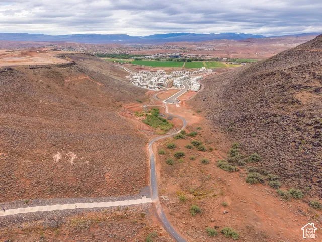 Aerial perspective featuring desert terrain, rugged mountain topography, and paved asphalt thoroughfares
