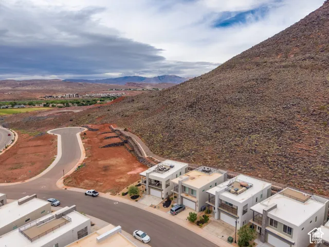 Aerial perspective of multi-level residences featuring flat rooflines, integrated rooftop decks, and stone-accented exteriors set against a prominent mountain backdrop