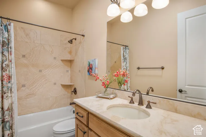 Bathroom featuring a single vanity with an oval sink, bronze-finish faucet, and a stone-finish countertop